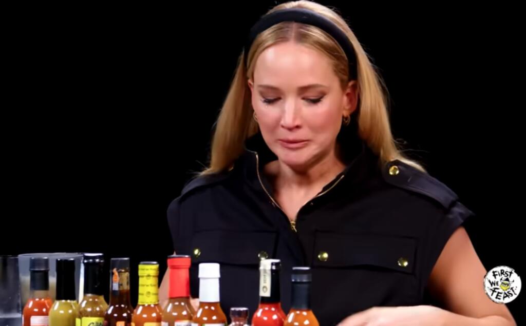 Jennifer Lawrence suffering through a tortuously spicy chicken wing while answering questions about her career on the YouTube show “Hot Ones.” (Hot Ones/First We Feat productions)