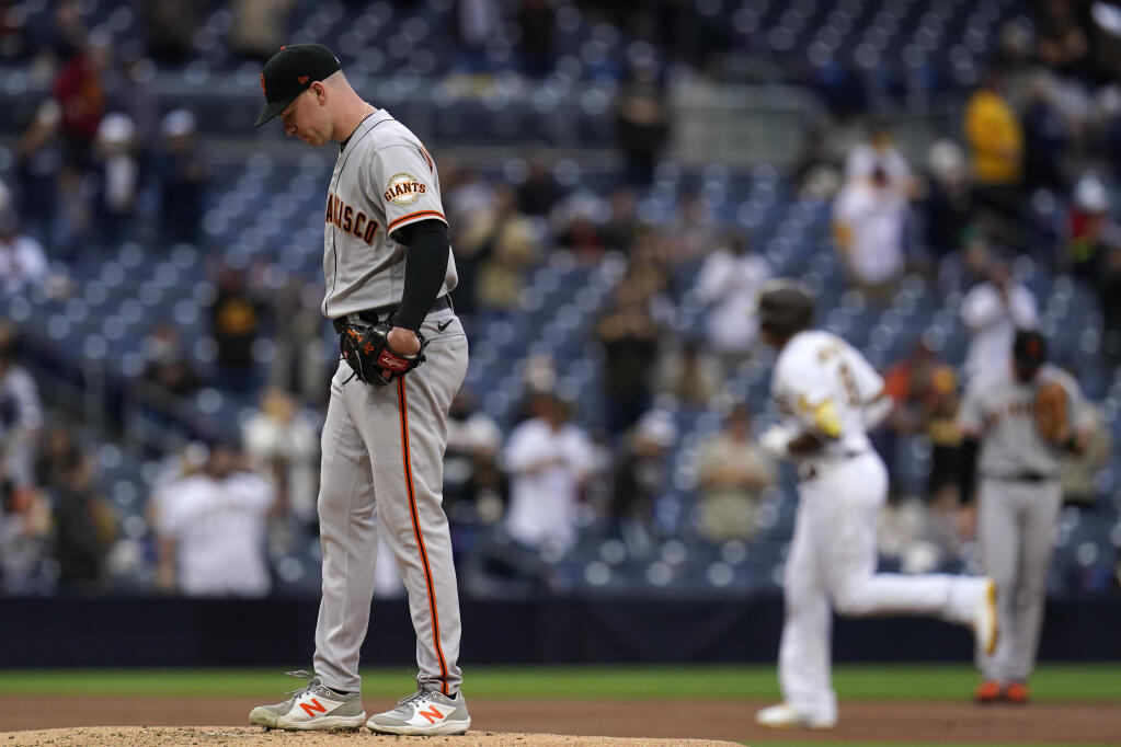 San Francisco Giants starting pitcher Anthony DeSclafani, left, stands on the mound as the San Diego Padres’ Manny Machado rounds the bases after hitting a three-run home run during the first inning on Saturday, May 1, 2021, in San Diego. (Gregory Bull / ASSOCIATED PRESS)