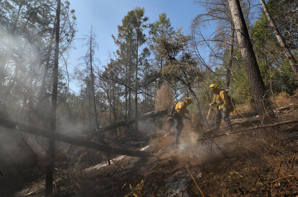 Los Angeles City Fire Department firefighters work on extinguishing hot spots along Pony Gate Trail in Sugarloaf Ridge State Park on Monday, Oct. 5, 2020.  (Christopher Chung / The Press Democrat)