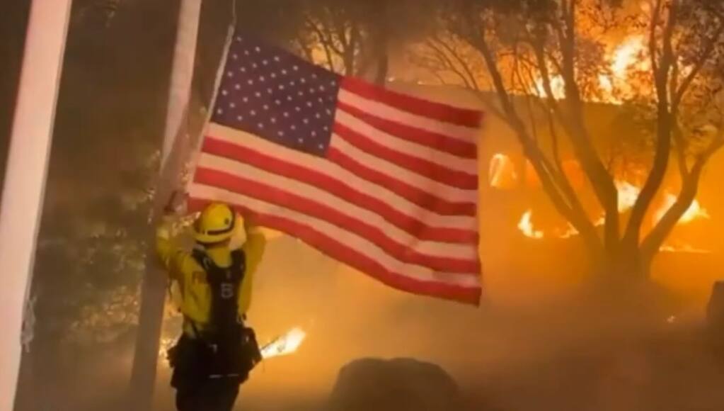 ‘BEHIND THE BURNING VINES’: Petaluma filmmaker Will Twomey teamed up with Santa Rosa’s Chris Kam to film a documentary last year during the Glass fire. In this shot from the film, responders rescue the flag at Fairwinds Estate Winery. “The only thing they saved was the American flag,” says General Manager Colin MacPhail. (COURTESY OF WILL TWOMEY/CHRIS KAM)