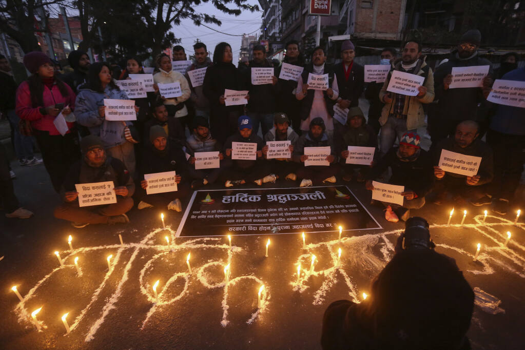 People observe a candlelight vigil in memory of victims of a plane crash in Kathmandu, Nepal, Monday, Jan. 16, 2023. The Yeti Airlines flight from Kathmandu that plummeted into a gorge Sunday killed at least 70 passengers out of the 72 on board. (AP Photo/Bikram Rai)