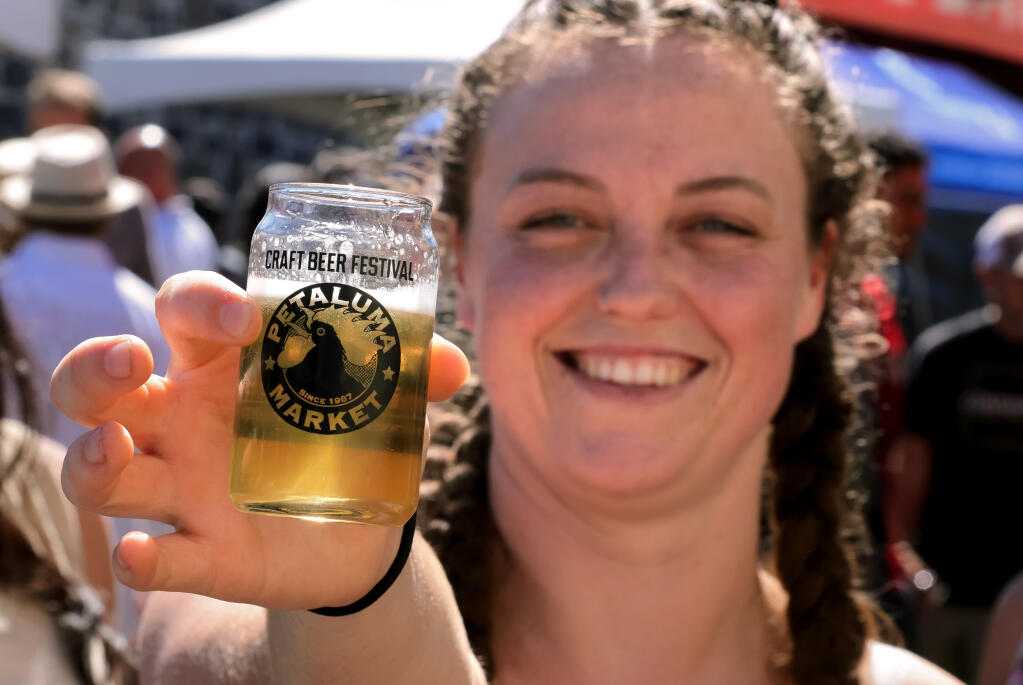 Kristen Willis of Petaluma holds a small glass of beer at the Petaluma River Craft Beer Festival in Petaluma. (Darryl Bush / For The Press Democrat file)