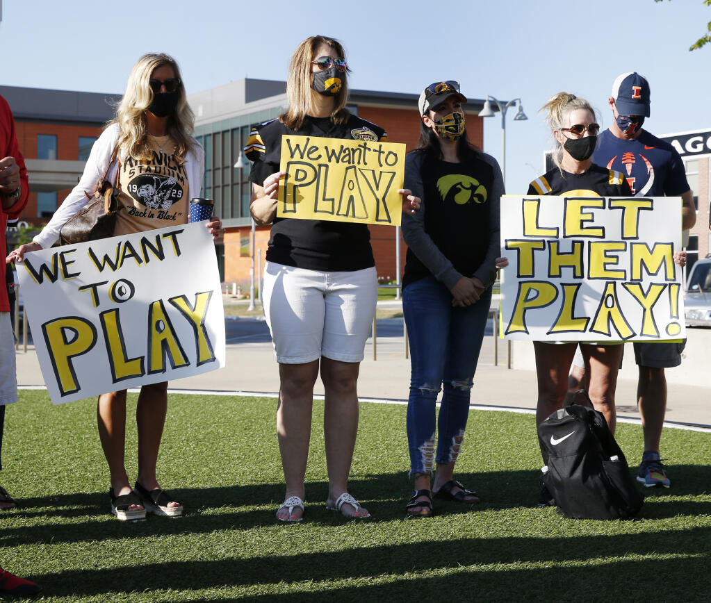 University of Iowa football parents hold signs of protest at a press conference asking for more transparency and communication by the Big Ten outside of the conference headquarters on Friday,  August 21, 2020 in Rosemont, Illinois. (Stacey Wescott / Chicago Tribune)