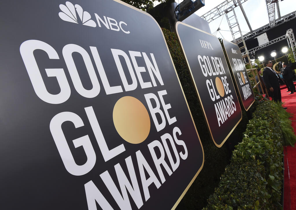 FILE - Event signage appears above the red carpet at the 77th annual Golden Globe Awards, Sunday, Jan. 5, 2020, in Beverly Hills, Calif. More than 100 Hollywood publicity firms that collectively represent the majority of stars in film and television, said they will advise their clients to skip the Golden Globes if the Hollywood Foreign Press Association does not commit to â€œtransformational change.â€  (Photo by Jordan Strauss/Invision/AP, File)
