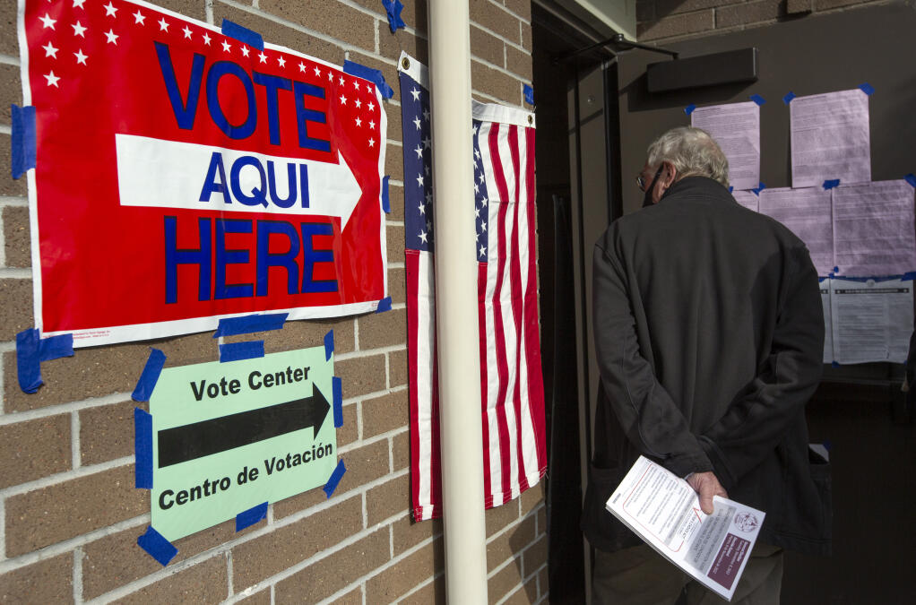 A voter holds onto his Sonoma County Voter Information Guide as he waits in line for in-person voting at the Sonoma Valley Regional Library on West Napa Street on Tuesday, Nov. 8, 2022. (Robbi Pengelly/Index-Tribune)