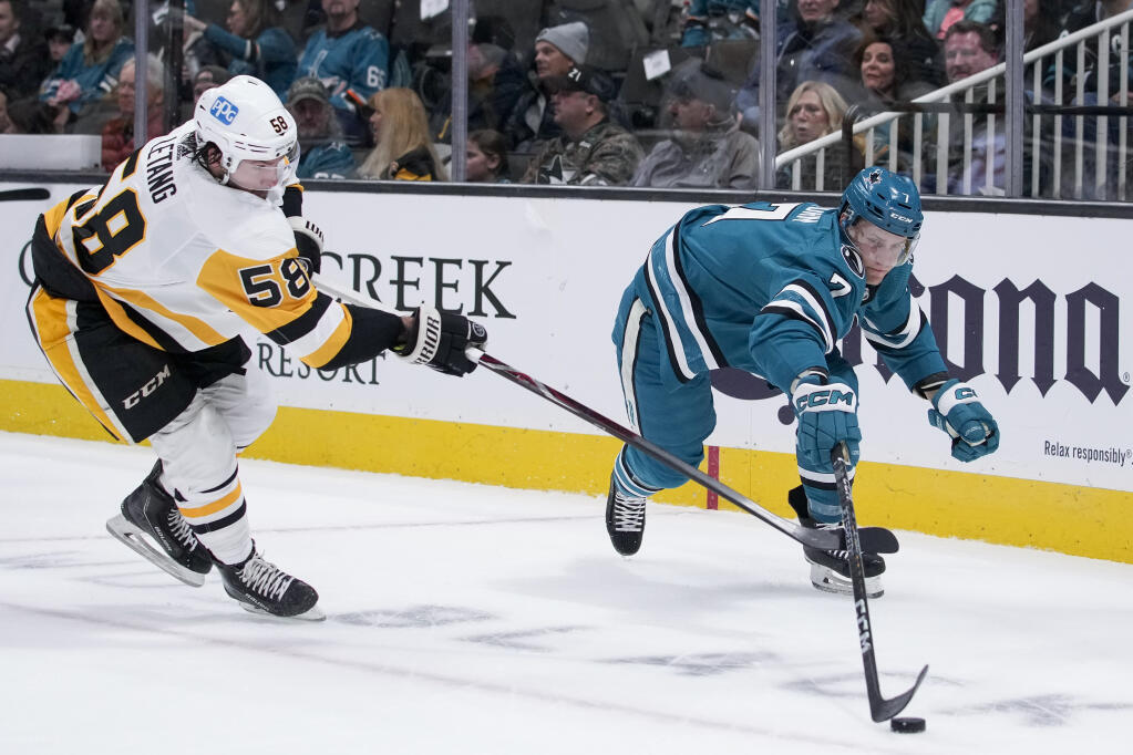 Pittsburgh Penguins defenseman Kris Letang, left, and Sharks center Nico Sturm chase after the puck during the first period in San Jose, Tuesday, Feb. 14, 2023. (Godofredo A. Vásquez / ASSOCIATED PRESS)
