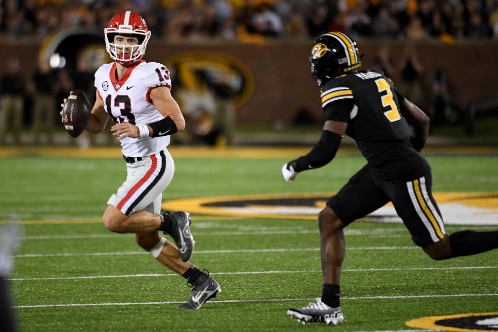 Georgia quarterback Stetson Bennett (13) scrambles as Missouri defensive back Martez Manuel (3) defends during the first half of an NCAA college football game Saturday, Oct. 1, 2022, in Columbia, Mo. (AP Photo/L.G. Patterson)