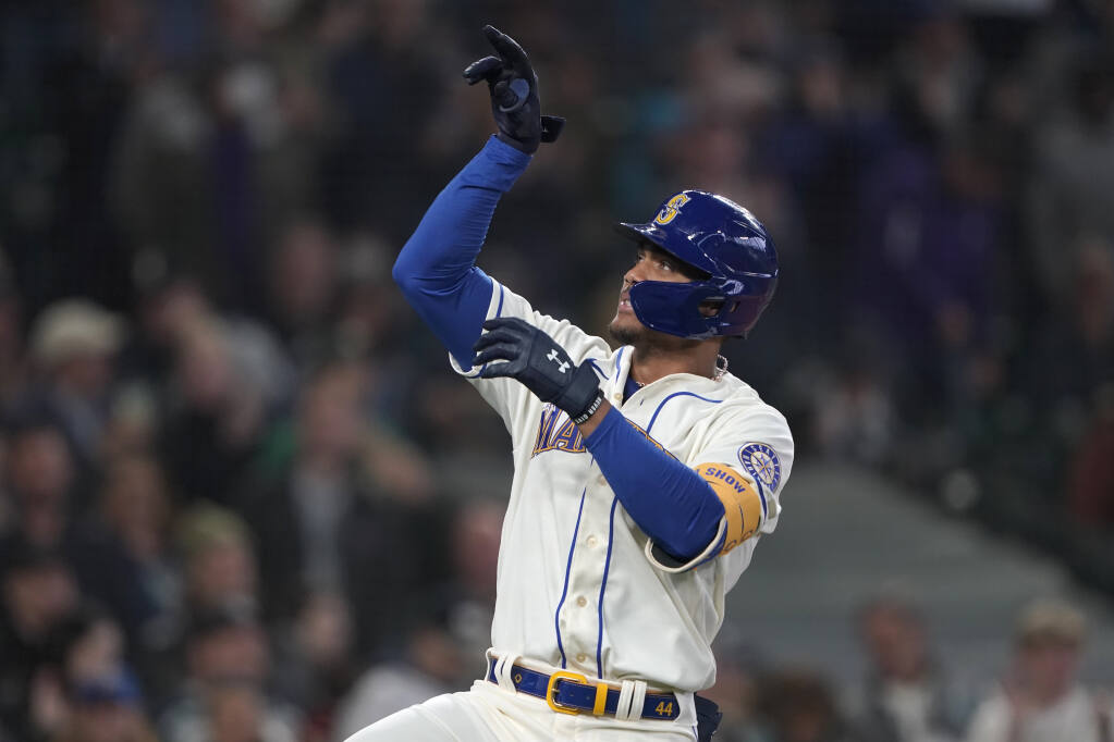 Seattle Mariners' Julio Rodriguez gestures after crossing the plate after he hit a solo home run against the Oakland Athletics during the first inning of a baseball game, Sunday, July 3, 2022, in Seattle. (AP Photo/Ted S. Warren)