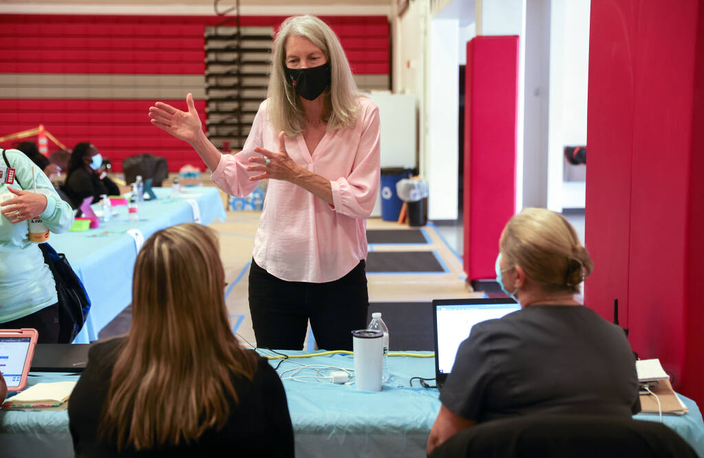 Healthcare Foundation of Northern Sonoma County executive director Kim Bender talks with Alliance Medical Clinic personnel at a COVID-19 vaccination clinic site at Healdsburg High School on Thursday, June 24, 2021.  (Christopher Chung/ The Press Democrat)