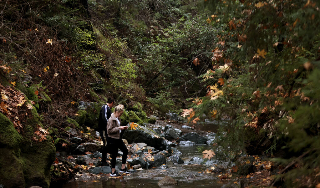 A couple enjoy Sonoma Creek where Chinook salmon have returned, Saturday, Nov. 13, 2021 at Sugarloaf Ridge State Park, thanks to October's atmospheric river that invigorated stream flows.  (Kent Porter / The Press Democrat) 2021