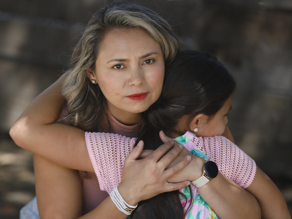 Maria Jasso, owner of Little Wildflowers Preschool, hugs her daughter Scarlett Banuelos Jasso, 8, on Sunday, May 29, 2022, in Santa Rosa, California. (Beth Schlanker/The Press Democrat)