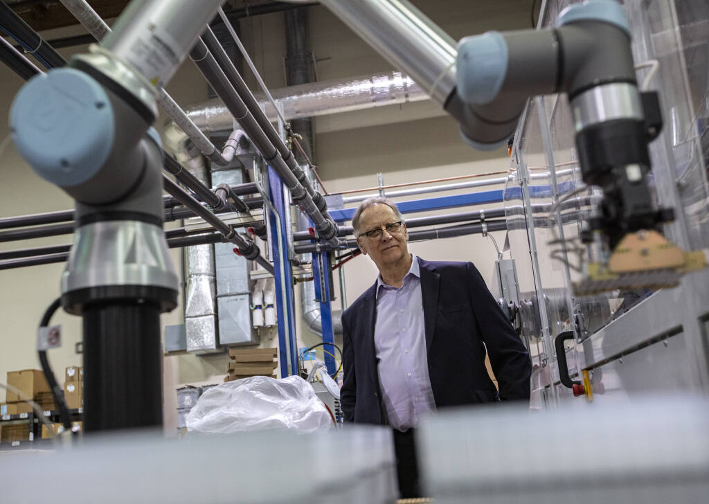 Labcon North America President Jim Happ looks over a robotic arm on his pipet tip machine which produces 400,000 units a day for Covid testing kits at the company’s Petaluma production facility Wednesday March 2, 2022. (Chad Surmick / The Press Democrat)
