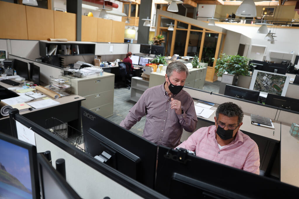 Jim Theiss, left, principal at Quattrocchi Kwok Architects, works with project designer Cam Hawing in their largely empty office in downtown Santa Rosa on Wednesday, August 11, 2021.  (Christopher Chung/ The Press Democrat)