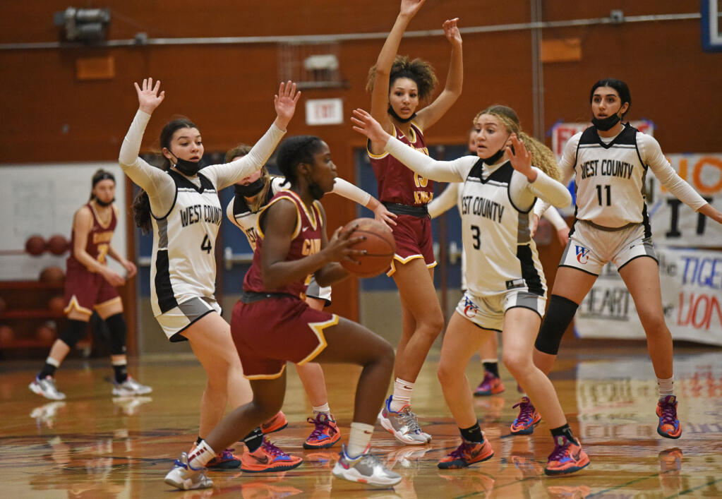 Reese Searcy, center, of Cardinal Newman going against heavy coverage from West County High during their North Bay League Oak division game at West County High School in Sebastopol on Wednesday, Jan. 12, 2022. (Erik Castro / for The Press Democrat)
