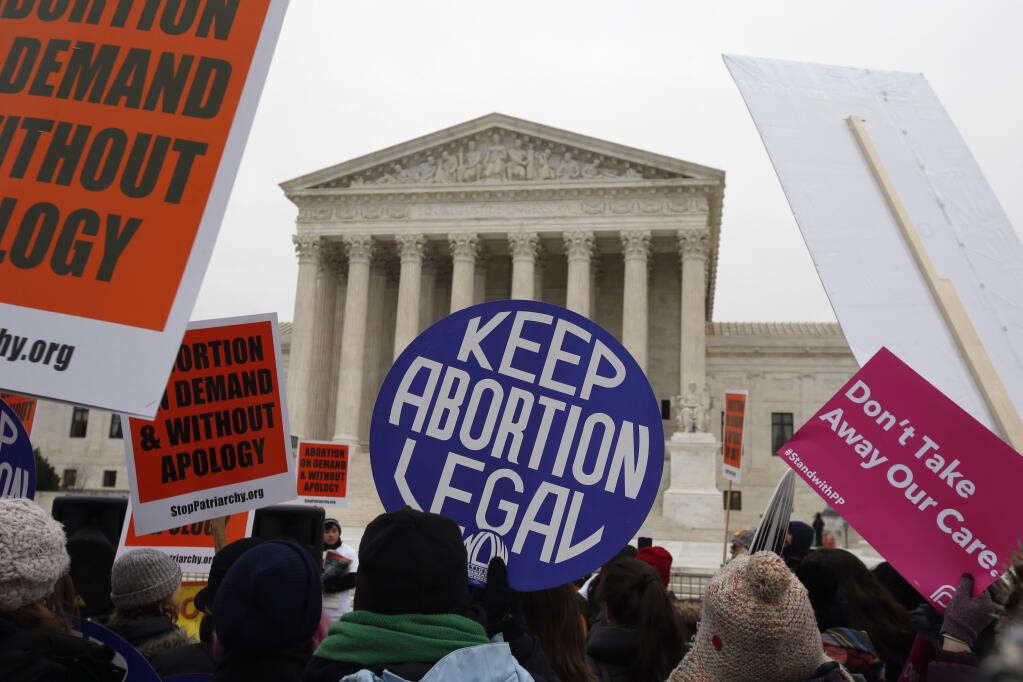 FILE - Pro-abortion rights signs are seen during the March for Life 2016 in front of the U.S. Supreme Court in Washington, Jan. 22, 2016. The North Dakota Supreme Court ruled Thursday, March 16, 2023, that a state abortion ban will remain blocked while a lawsuit over its constitutionality proceeds. (AP Photo/Alex Brandon, File)