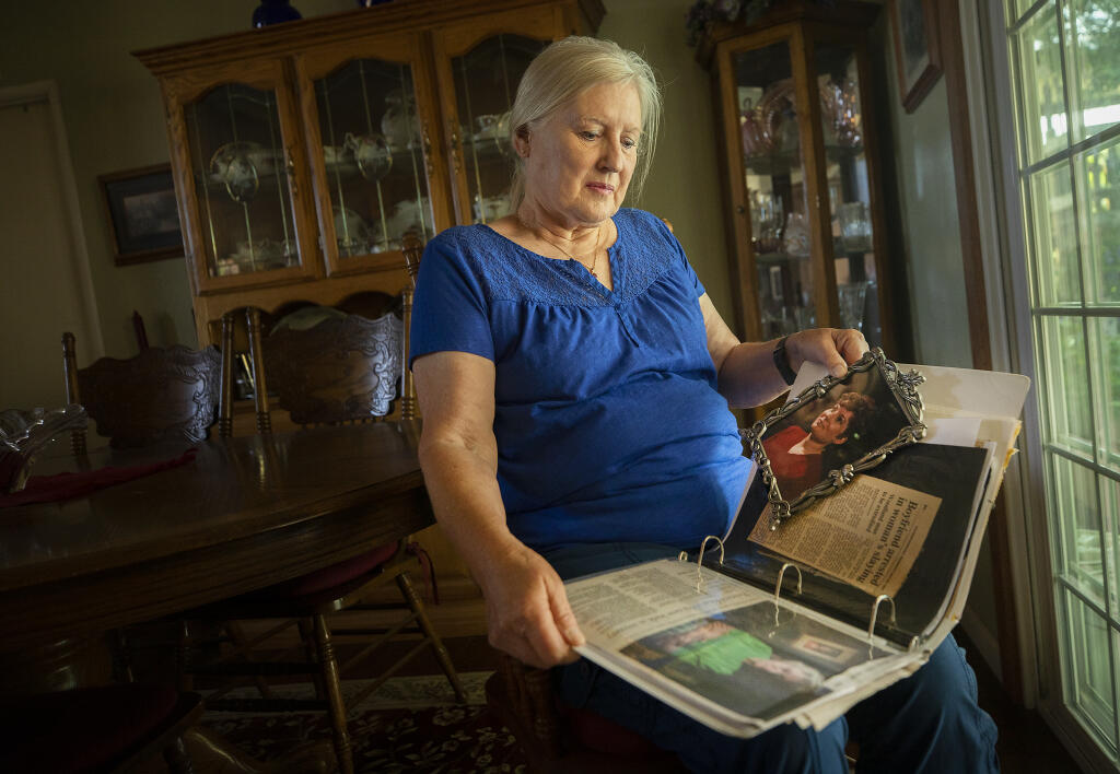 Diane Parker flips through a scrapbook of stories about the death of her sister, Sarah Hutchings, who was found murdered in her Santa Rosa home in 1991.  DNA testing has led police to find a new suspect in the killing, who died of an overdose in 2001. Parker was photographed in her Ukiah home on Tuesday, June 8, 2021.  (John Burgess/The Press Democrat)