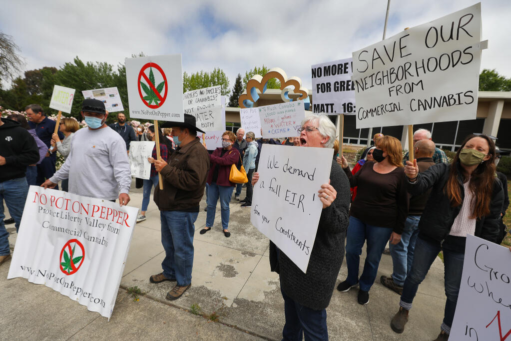 Karen Harter, center, joins protesters opposing cannabis farms in Sonoma County, in front of the Sonoma County Board of Supervisors chambers, in Santa Rosa on Monday, May 17, 2021.  (Christopher Chung/ The Press Democrat)