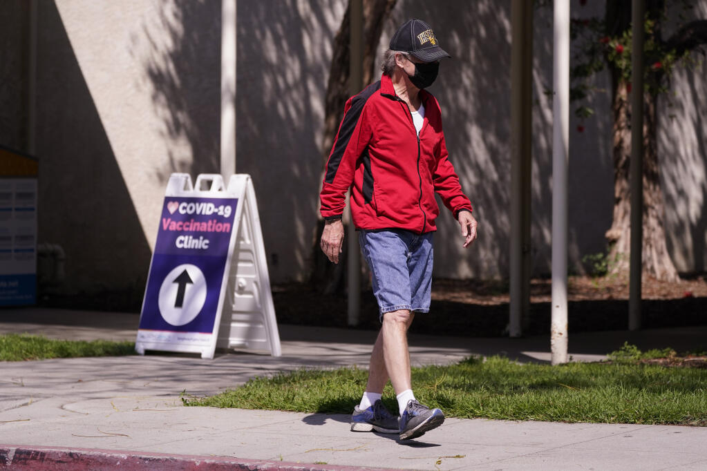 A man leaves a testing and vaccination clinic for COVID-19 Wednesday, March 30, 2022, in Long Beach, Calif.  (AP Photo/Ashley Landis)