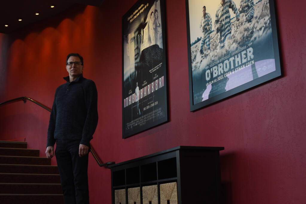 Ky Boyd, owner of Rialto Cinemas near a couple of Coen Brothers movie posters in the theater lobby in Sebastopol, California on Friday, December 4, 2020. The theater was shut for months because of COVID-19 restrictions. (Erik Castro/for The Press Democrat)