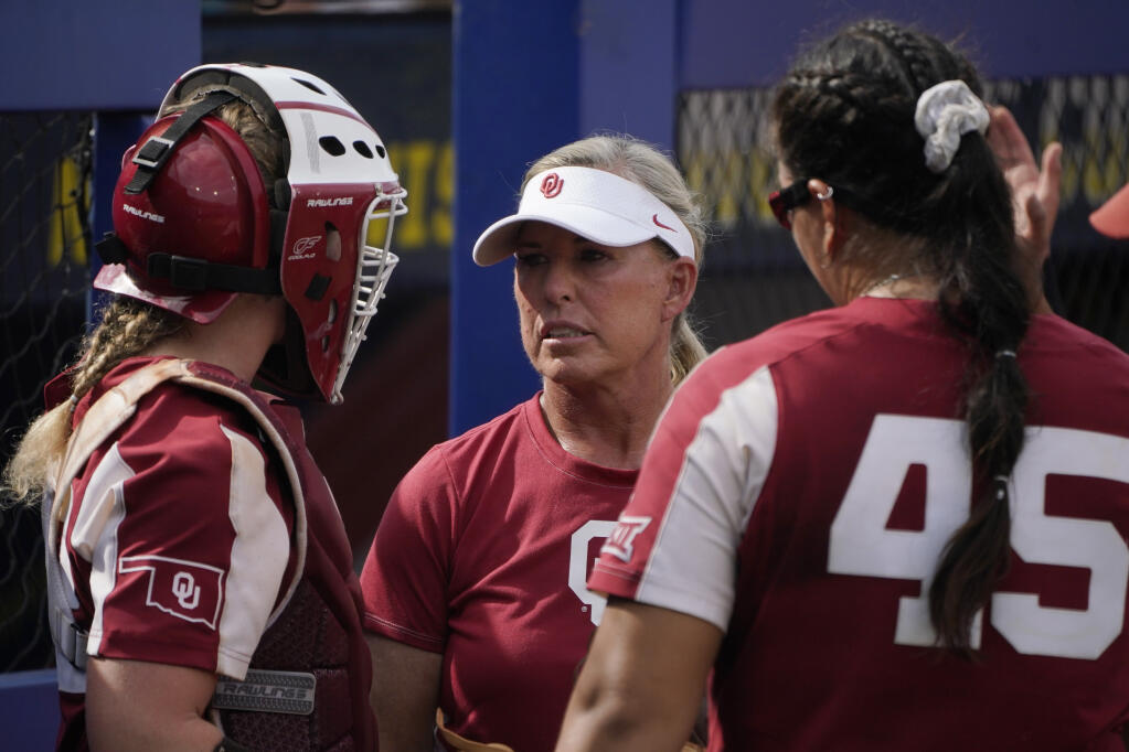 Oklahoma coach Patty Gasso, center, talks with catcher Lynnsie Elam, left and pitcher Giselle Juarez during the team’s Women's College World Series softball game against James Madison on Monday, June 7, 2021, in Oklahoma City. (Sue Ogrocki / ASSOCIATED PRESS)