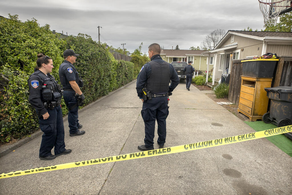 Santa Rosa police stand guard over a Aston Avenue home, right, in Santa Rosa where two people were found dead on Thursday, May 5, 2022.  (John Burgess/The Press Democrat)