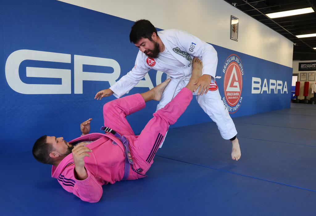 Brenten Bailey, left, practices using his legs to keep Mitchell Quintanilla at bay while on his back during the adult all-level class at Gracie Barra Brazilian Jiu-Jitsu in Rohnert Park on Monday, July 11, 2022. (Christopher Chung / The Press Democrat)