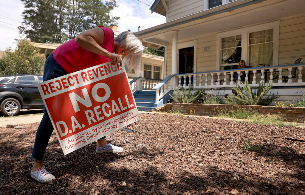 Cindy Williams, a volunteer for Sonoma County D.A. Jill Ravitch, places no recall signage in Lianne Rogers front yard, Tuesday, July 27, 2021 in Santa Rosa,  (Kent Porter / The Press Democrat) 2021