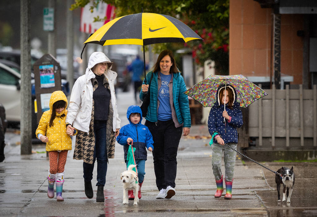 From left, Ryan, 6, Nicole, Ronan, 3, Kara and Tatum, 6, Ahlgren-Formanek, of Pleasant Hill, geared up for the wet weather on a day outing to the Sonoma Plaza Monday, January 2, 2023.   In spite of the cold, their destination was an ice cream shop they remembered from a previous visit. (John Burgess/The Press Democrat)
