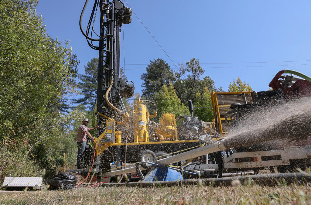 Water flows from a pipe as Nick Riojas, with Weeks Drilling & Pump Co., installs a new well along Furlong Road in Sebastopol, Friday, Sept. 16, 2022. (Christopher Chung / The Press Democrat file)