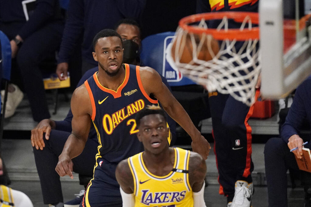 Golden State Warriors forward Andrew Wiggins, left, watches along with Los Angeles Lakers guard Dennis Schroder as his shot goes in during the first half of an NBA basketball Western Conference Play-In game Wednesday, May 19, 2021, in Los Angeles. (AP Photo/Mark J. Terrill)