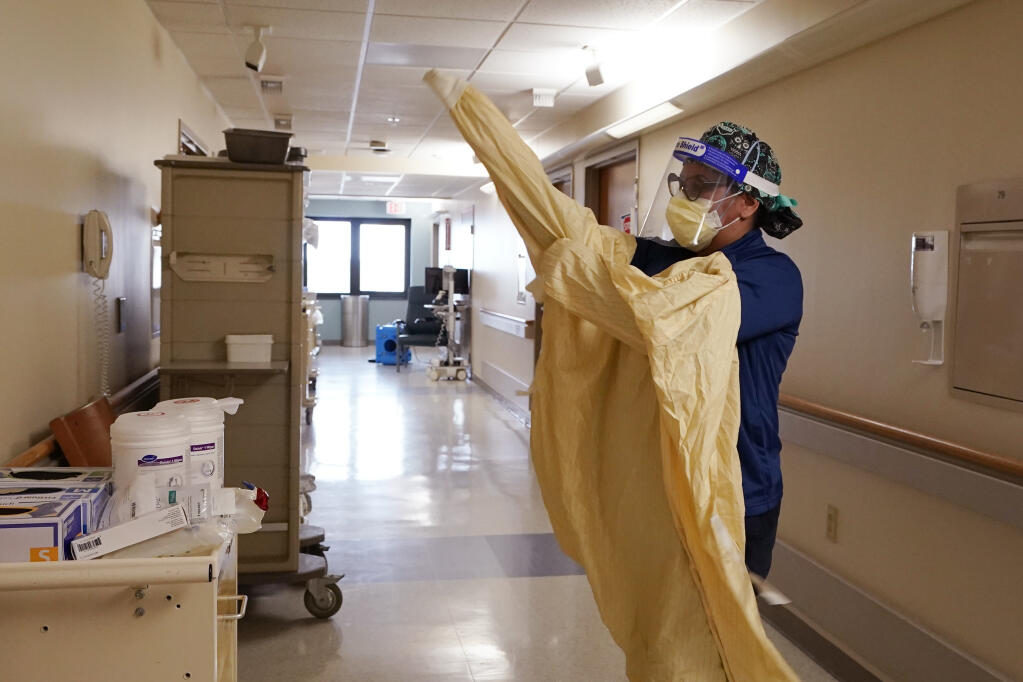 FILE - In this April 21, 2021 file photo, a registered dons protective gear before entering a room at a hospital in Royal Oak, Mich. (AP Photo/Carlos Osorio, File)