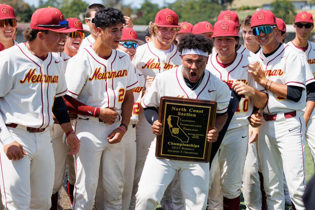 Cardinal Newman’s Justice Brinson, holding a plaque, celebrates their win against Campolindo 2-1 surrounded by teammates during the North Coast Section Division 3 championship game at Cardinal Newman High School on May 27, 2023. (Abraham Fuentes/ For The Press Democrat)