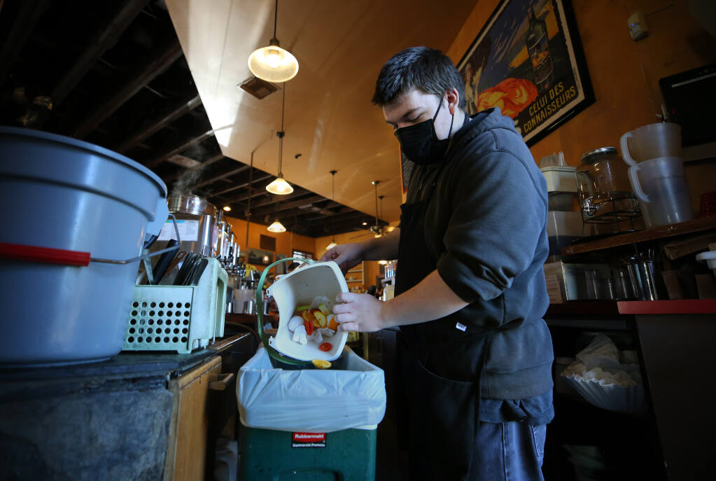 Employee Cam MacBride empties a small compost into a larger one at A'Roma Roasters Coffee & Tea in Santa Rosa on Wednesday, Jan. 19, 2022. (Beth Schlanker/The Press Democrat)