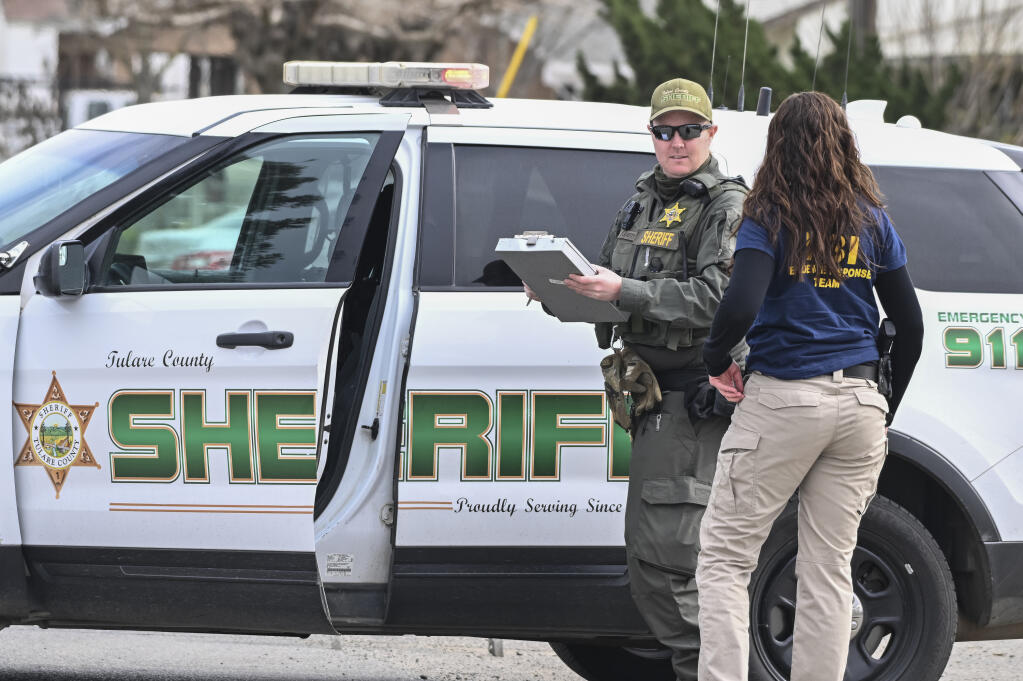 Investigators from several agencies work, Friday, Feb. 3, 2023, on Avenue 308 in Goshen, Calif., where one of two arrests were made for the Jan. 16 homicide of six people nearby. The suspect was shot by an ATF agent but is expected to live. Another suspect was apprehended in Visalia, the other just blocks away from the crime scene. (Ron Holman/The Times-Delta via AP)