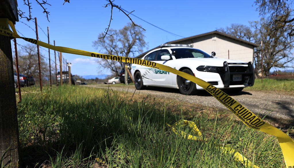 Crime scene tape flutters in the wind at the driveway entrance to a shooting scene on Hall Road, Saturday, March 25, 2023 between Santa Rosa and Sebastopol. (Kent Porter / The Press Democrat)
