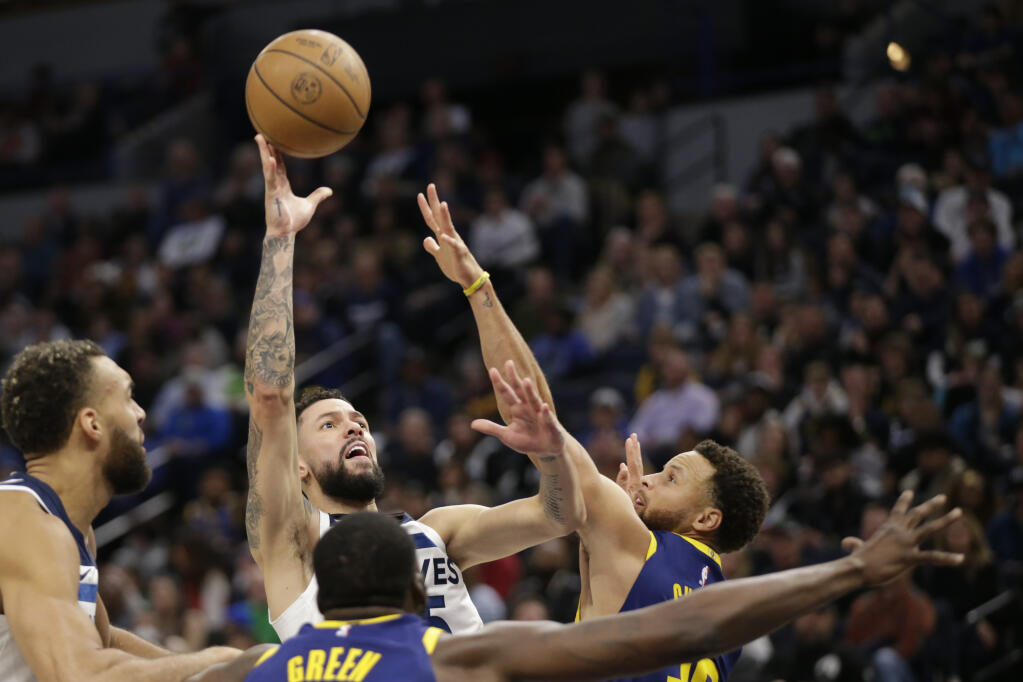 Minnesota Timberwolves guard Austin Rivers shoots over Golden State Warriors guard Stephen Curry, right, during the second quarter of an NBA basketball game Sunday, Nov. 27, 2022, in Minneapolis. (AP Photo/Andy Clayton-King)