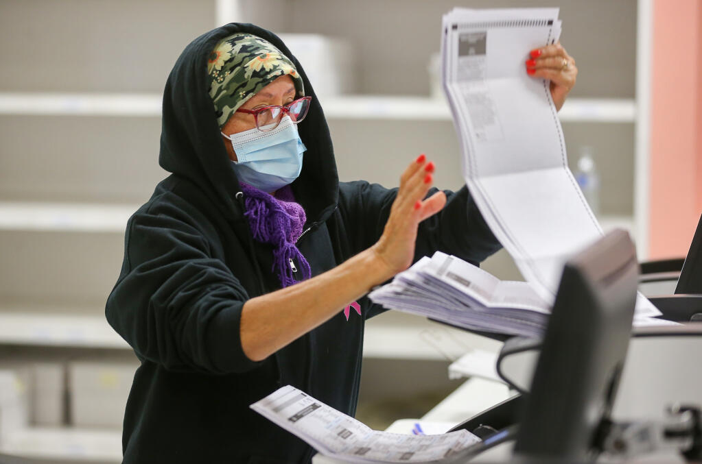 Julia Poncia removes ballots after they are scanned at the Sonoma County Registrar of Voters Office in Santa Rosa on Wednesday, November 2, 2022.  (Christopher Chung/The Press Democrat)