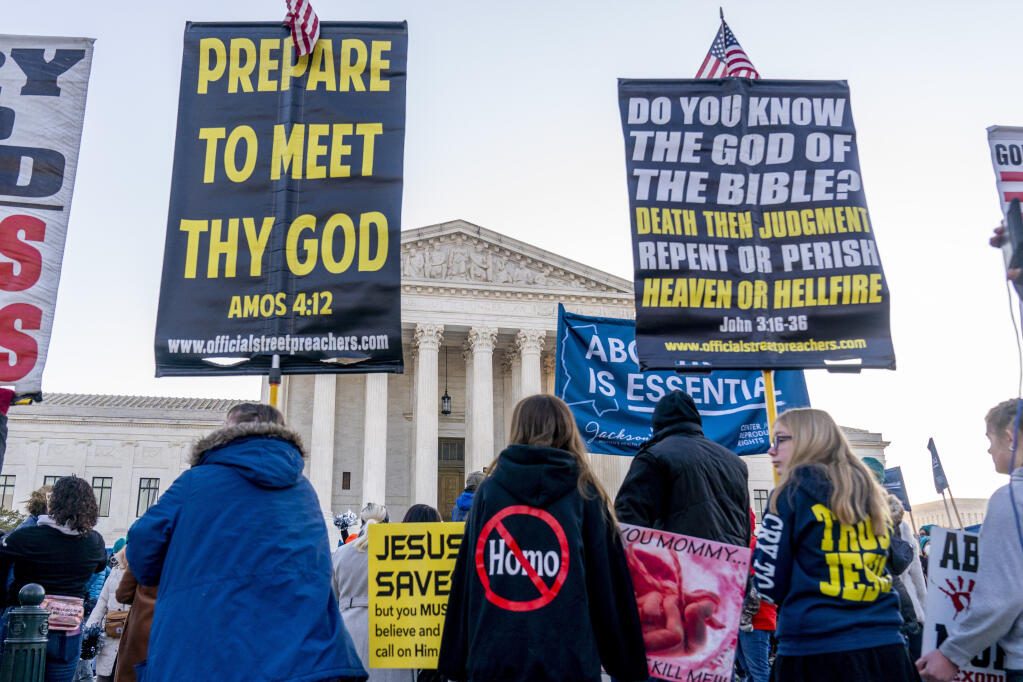 Anti-abortion protesters and abortion rights advocates demonstrate in front of the U.S. Supreme Court, Wednesday, Dec. 1, 2021, in Washington, as the court hears arguments in a case from Mississippi, where a 2018 law would ban abortions after 15 weeks of pregnancy, well before viability. (AP Photo/Andrew Harnik)