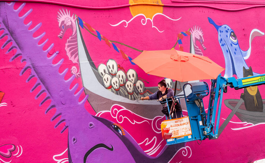 Los Angeles artist Allison Bamcat works on her large-scale mural in a parking lot at 501 Mendocino Ave. in Santa Rosa, Friday, Oct. 13, 2023. (John Burgess / The Press Democrat)