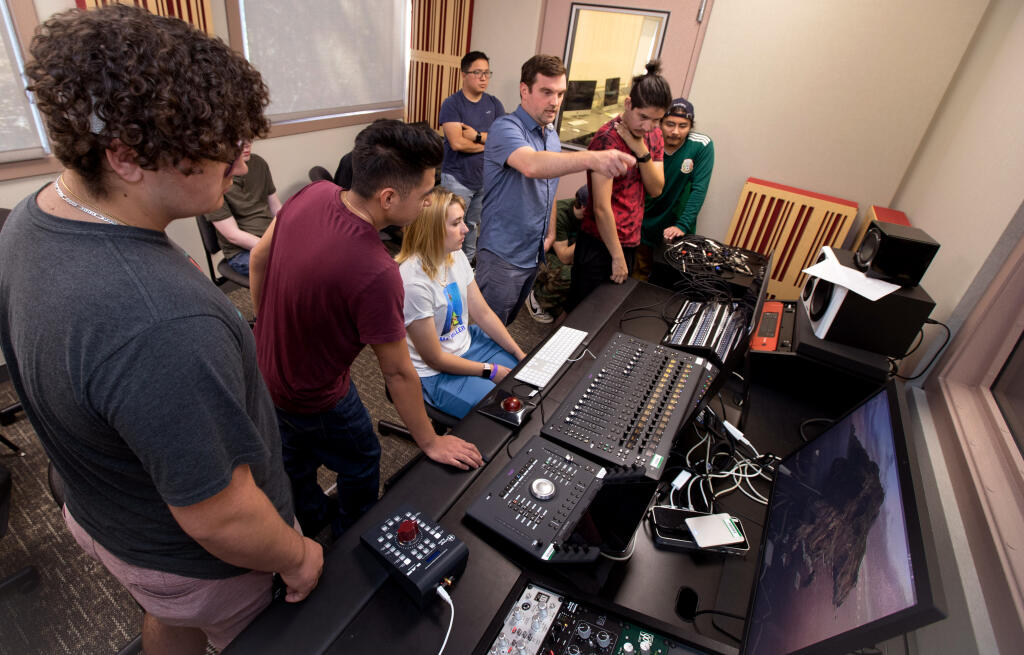 Music recording instructor Jacob Stillman, center right, shows students how to set up for recording in the sound room during a music industry fundamentals class at Santa Rosa Junior College’s Petaluma campus. (Darryl Bush / For The Press Democrat)