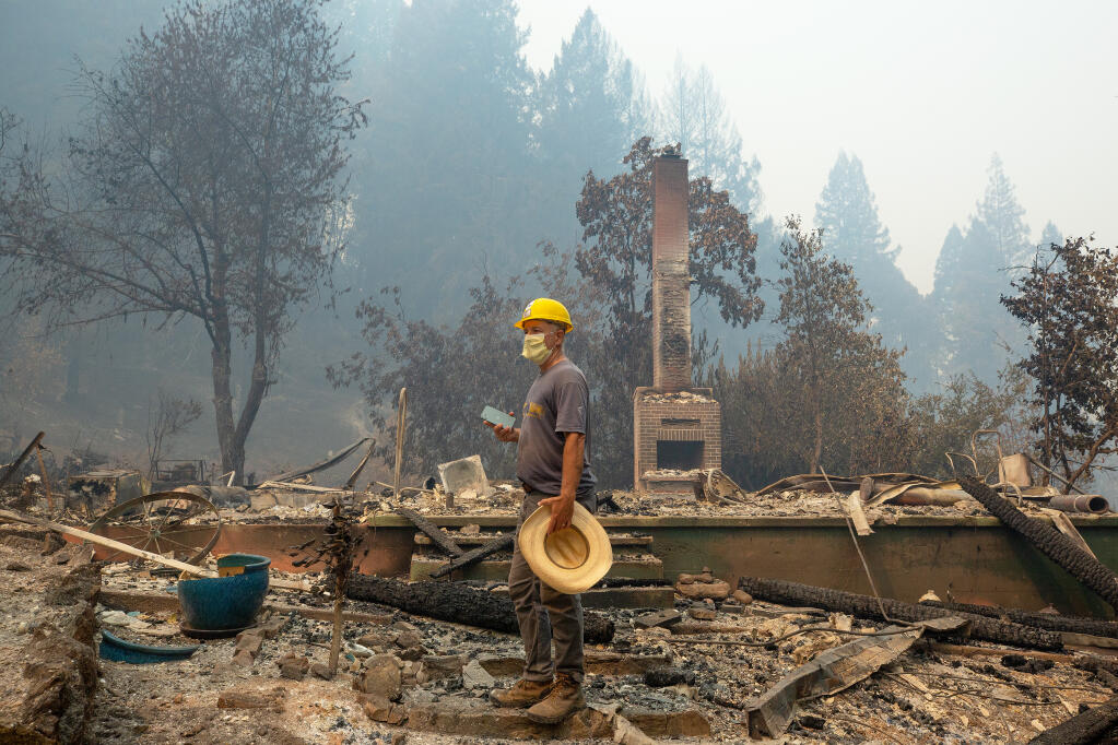 Dan Grout stands at the front steps of his home to document the devastation left by the Walbridge fire with his smartphone after the firestorm destroyed his family's homestead on Mill Creek Road near Healdsburg on Wednesday, Aug. 26, 2020. Grout is part of the Pitkin family that has lived on Mill Creek Road for five generations and was pivotal in restoring the Daniels School in the old mill town of Venado. (Alvin A.H. Jornada / The Press Democrat)