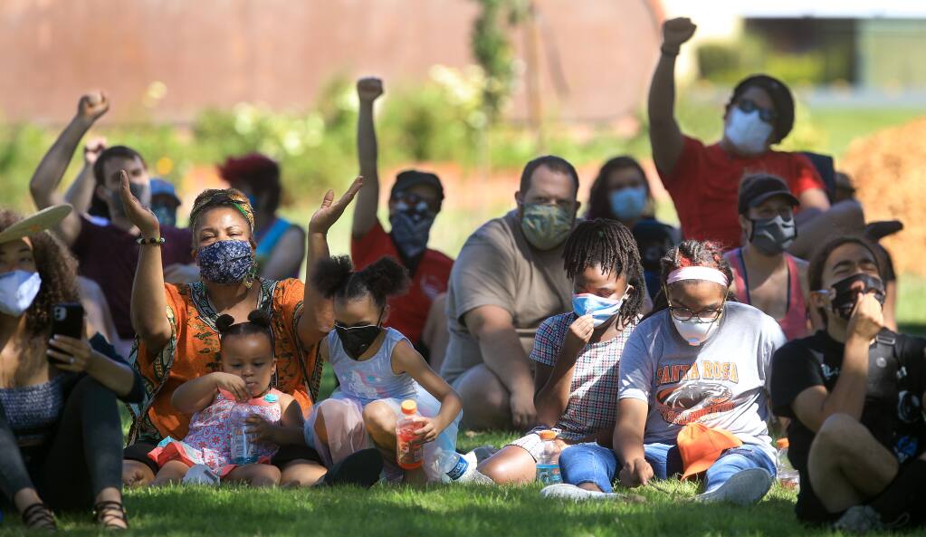 During the Uplifting Black Leaders social justice protest at Santa Rosa Junior College, people take cover in the shade and react as organizers speak to the crowd prior to a march to Old Courthouse Square in Santa Rosa, Saturday, July 11, 2020.   (Kent Porter / The Press Democrat) 2020