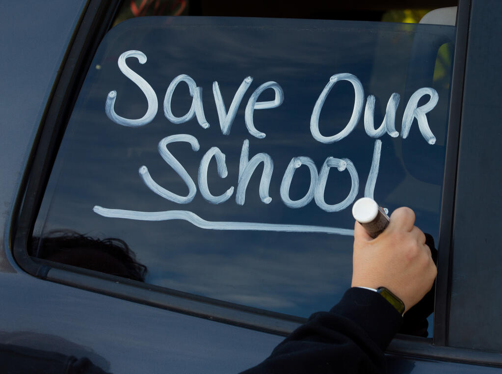 Jennifer Maples writes a message on her truck window in support of keeping El Molino High School open, in Forestville, California, on Saturday, Nov. 14, 2020. (Alvin A.H. Jornada / The Press Democrat)