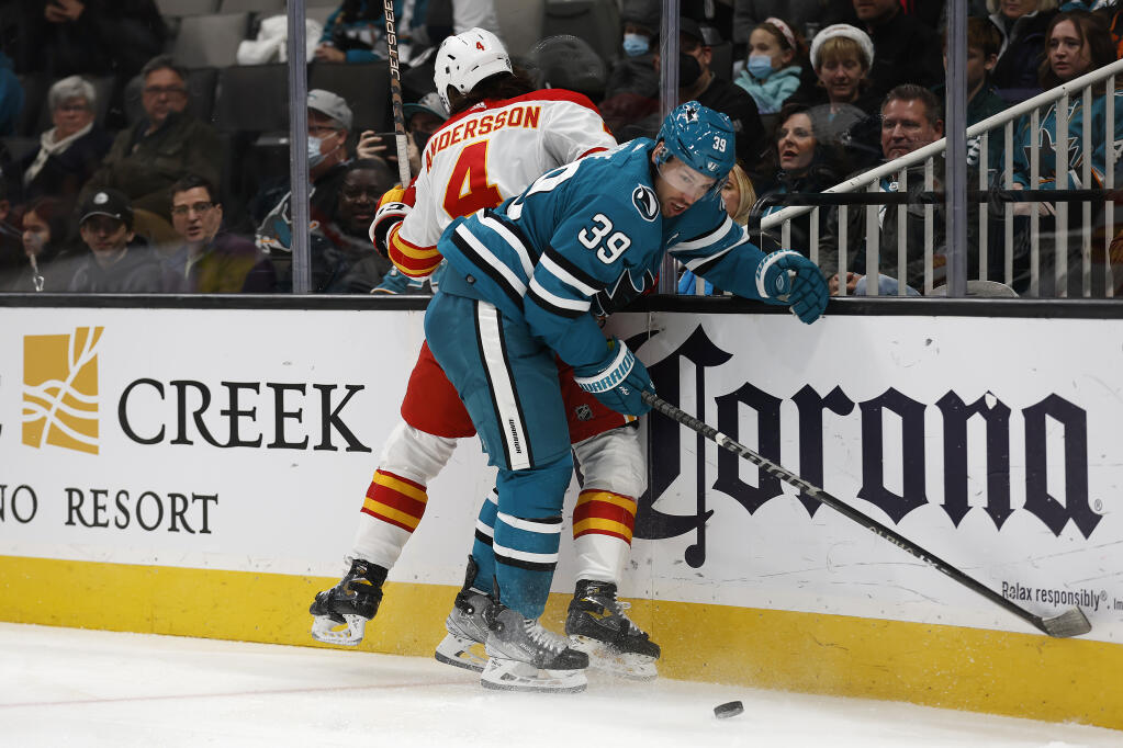 Calgary Flames defenseman Rasmus Andersson battles for the puck against Sharks center Logan Couture in the first period Tuesday, Dec. 20, 2022, in San Jose. (Josie Lepe / ASSOCIATED PRESS)