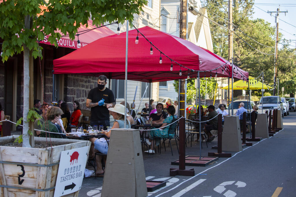 A portion of First Street East is completely closed to traffic in order to accommodate restaurant and tasting room parklets, such as the one erected by Maya above. (Photo by Robbi Pengelly/Index-Tribune)