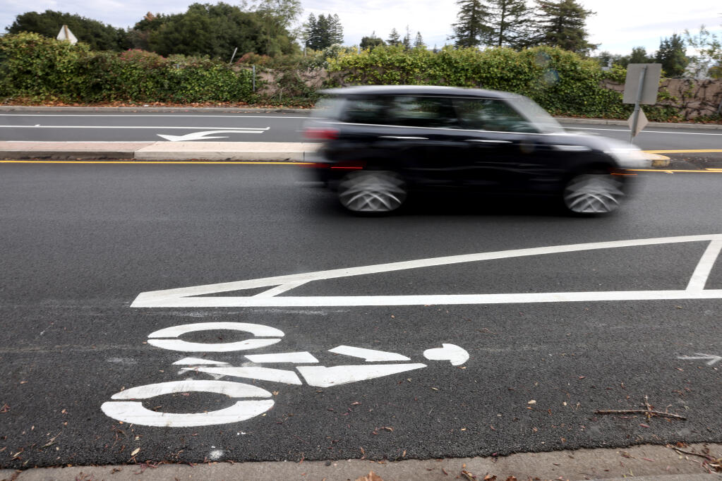 A car drives next to a buffered bike line on Freeway Drive in Napa, Wednesday, Oct. 25, 2023. (Beth Schlanker / The Press Democrat)