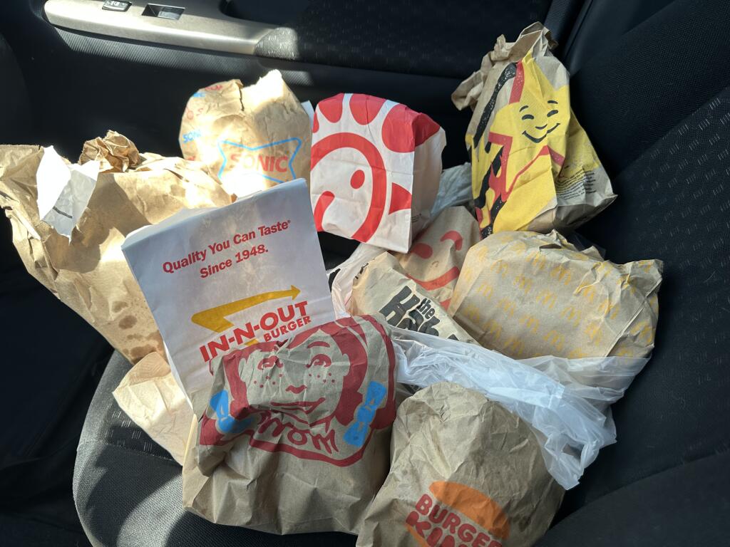 This image taken Thursday, July 13, 2023, shows bags from local fast food restaurants in the car of a Press Democrat reporter. The reporter sampled French fries in honor of National French Fry Day. (Colin Atagi / The Press Democrat)