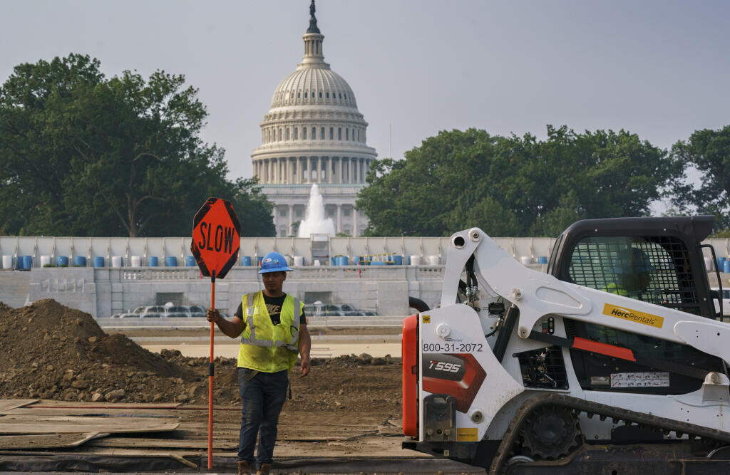 Workers repair a park near the Capitol in Washington, Wednesday, July 21, 2021, as senators struggle to reach a compromise over how to pay for nearly $1 trillion in public works spending, a key part of President Joe Biden's agenda. (AP Photo/J. Scott Applewhite)