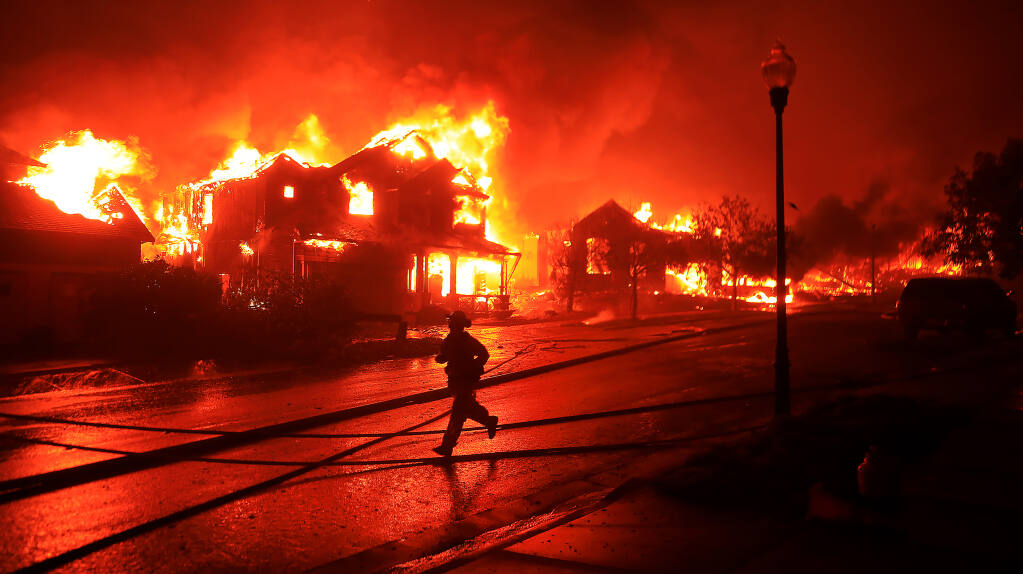 Houses burn on Mountain Hawk Drive in Santa Rosa's Skyhawk Community as the Glass Fire rolls in from Napa County on Sept. 28, 2020. In all, 11 homes burned in the area, but firefighters saved hundreds of others.  (Kent Porter / The Press Democrat) 2020