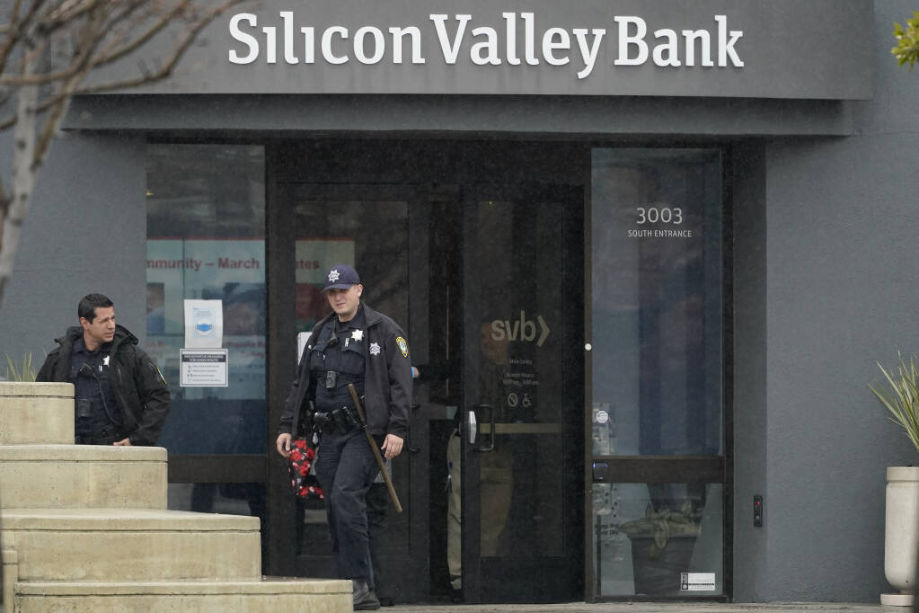 Santa Clara Police officers exit Silicon Valley Bank in Santa Clara, Calif., Friday, March 10, 2023. The Federal Deposit Insurance Corporation is seizing the assets of Silicon Valley Bank, marking the largest bank failure since Washington Mutual during the height of the 2008 financial crisis. The FDIC ordered the closure of Silicon Valley Bank and immediately took position of all deposits at the bank Friday.  (AP Photo/Jeff Chiu)